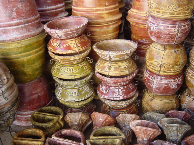Several medium-sized, authentic Mexican clay pots adorned with vibrant Mexican-colored wrought iron.
