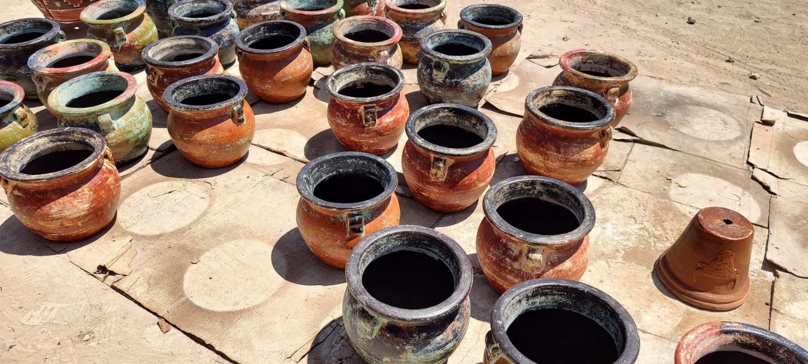 Artistic painting of beautiful clay pots by a skilled Mexican Pottery Manufacturer, showcasing rustic colors.